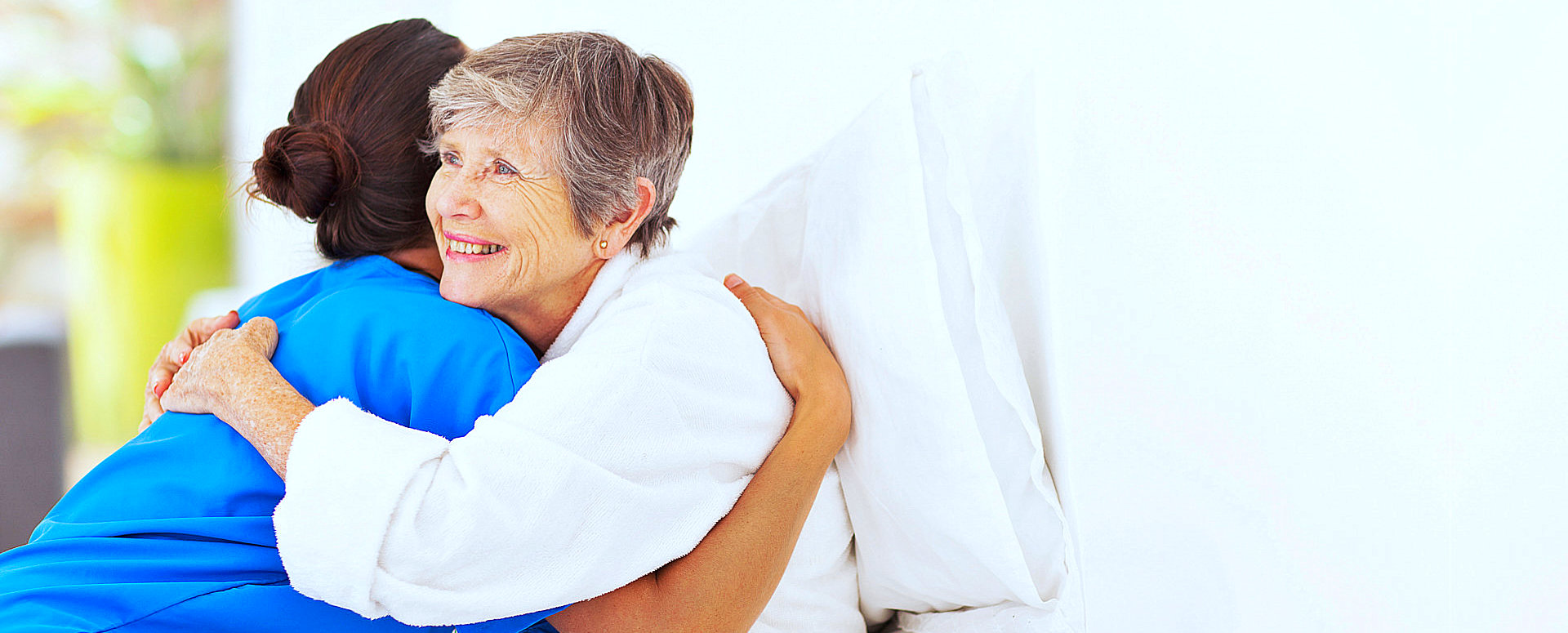 caregiver and elder woman hugging
